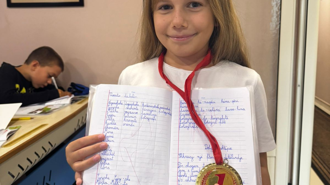 Nxënëse me fletore dhe medalje